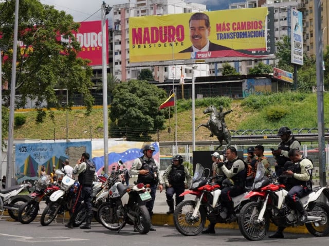 police officers stand near a hoarding with an image of venezuela s president nicolas maduro in caracas venezuela july 31 2024 photo reuters